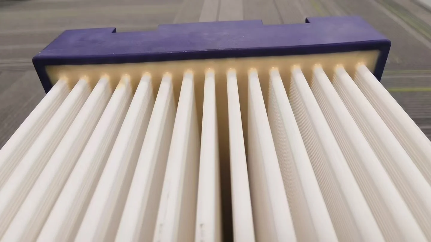 Close-up view of parallel ceramic flat sheet membrane plates entering the module end frame