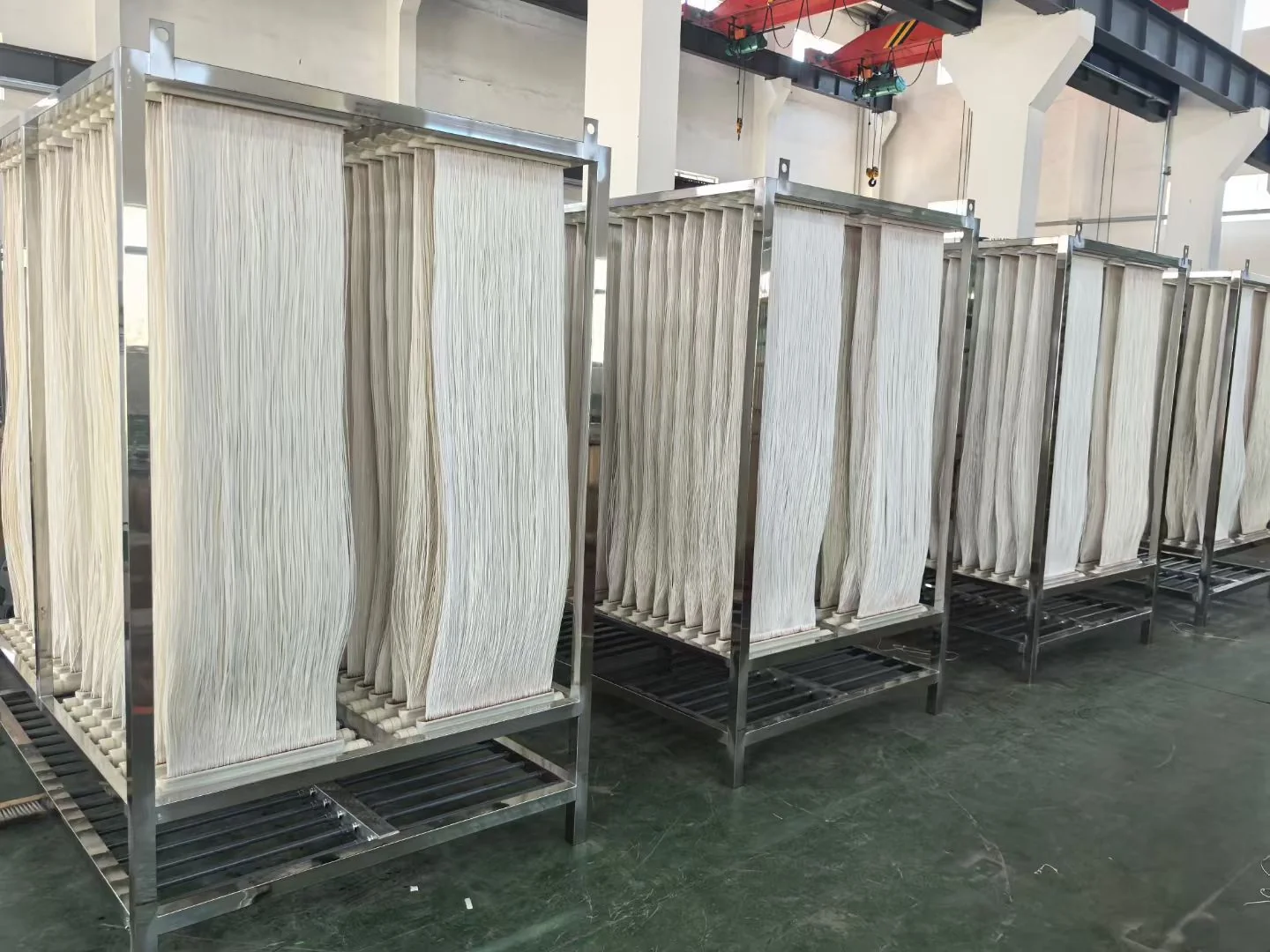 Rows of stainless steel hollow fiber MBR membrane modules in a manufacturing workshop